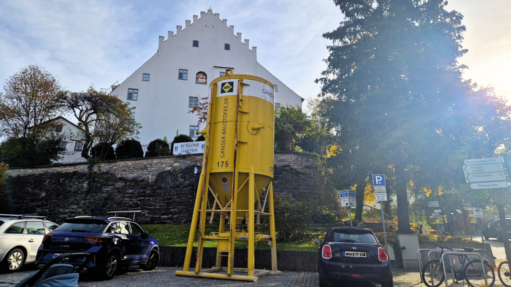 Autos auf einem Parkplatz, dahinter das Murnauer Schloßmusuem