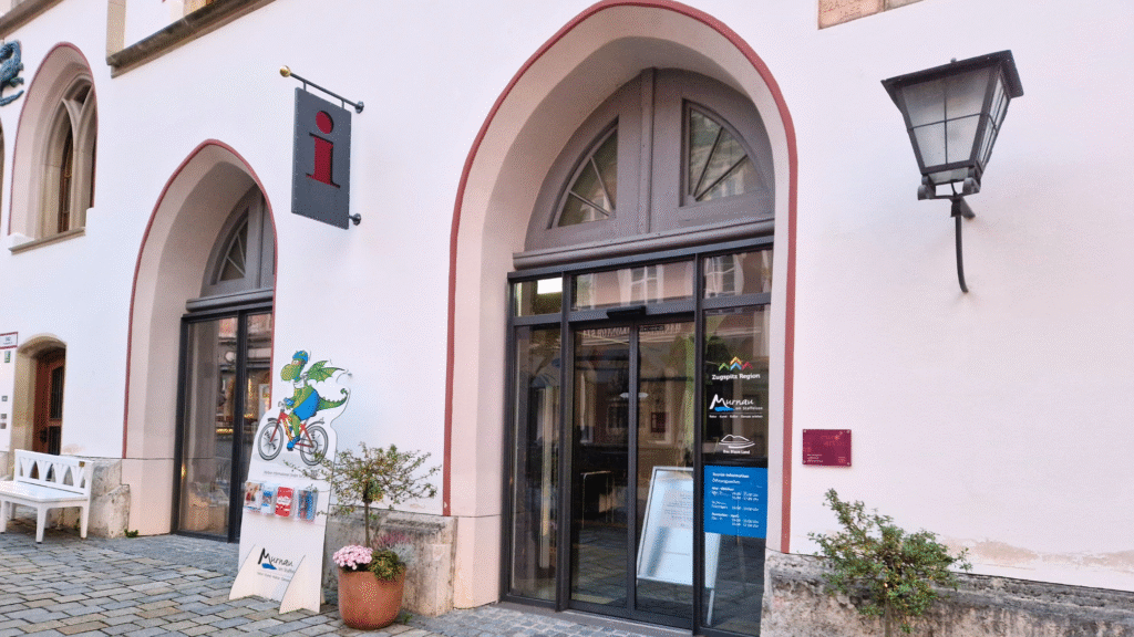 Tourist Information Murnau Außenansicht - ein Gebäude mit gewölbten Türen und einem Schild