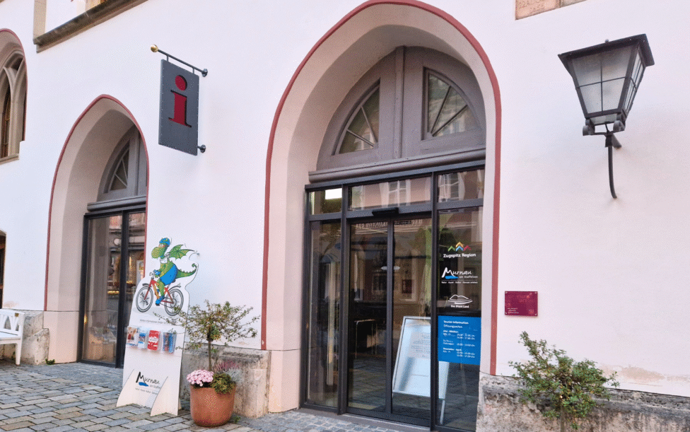 Tourist Information Murnau Außenansicht - ein Gebäude mit gewölbten Türen und einem Schild
