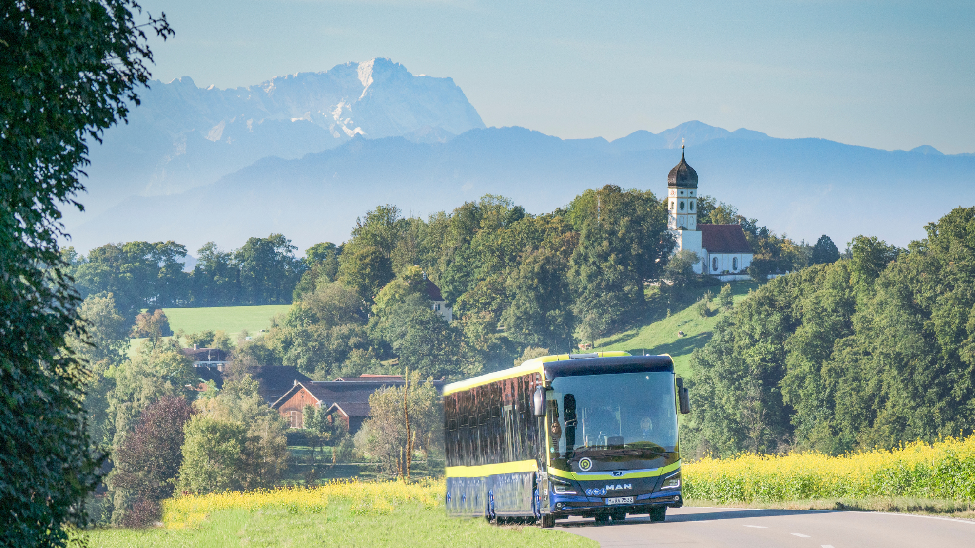 Der Alpenbus vor der Kulisse des Wettersteingebirges mit der Zugspitze.
