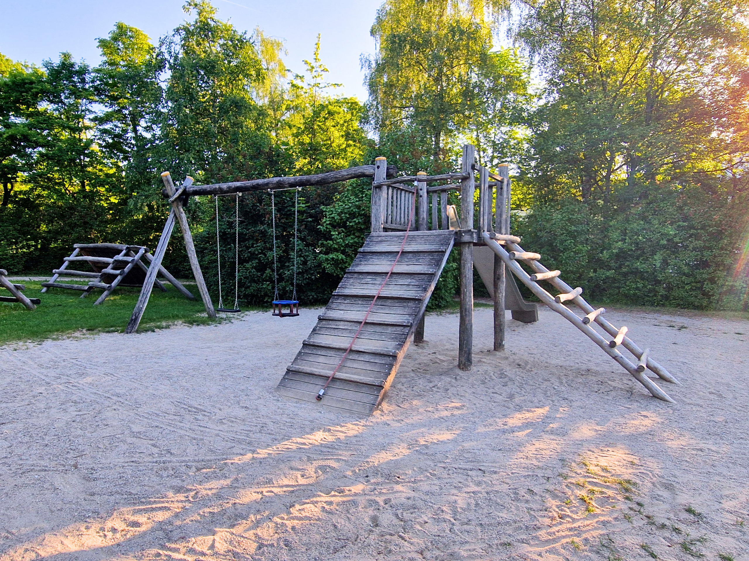 Blick auf den Spielplatz im Murnauer KulturPark mit Klettergerüst und Schaukeln